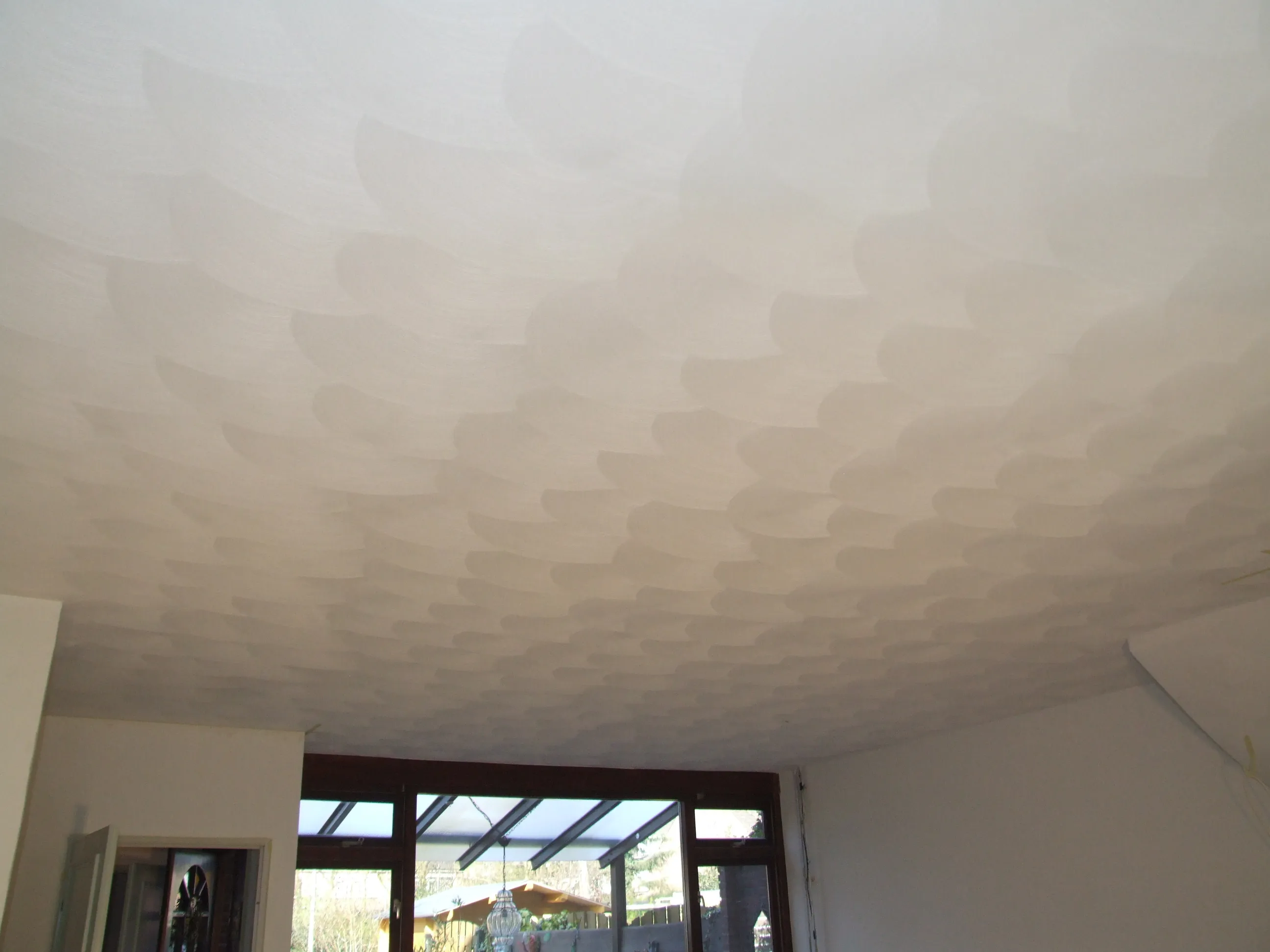 Handmatig schuurwerk met een wolkachtige structuur op een plafond